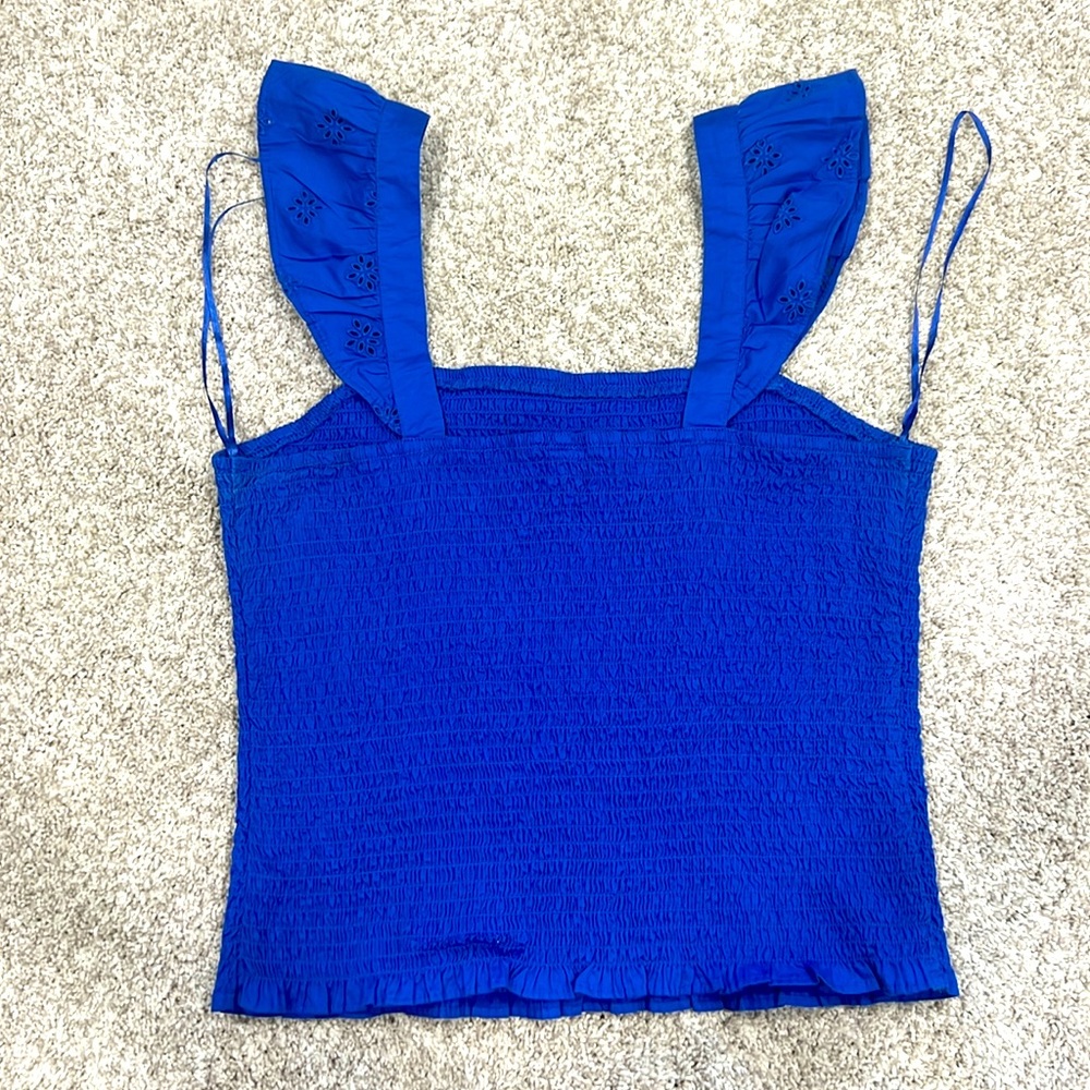 Blue tank top with ruffle sleeves.